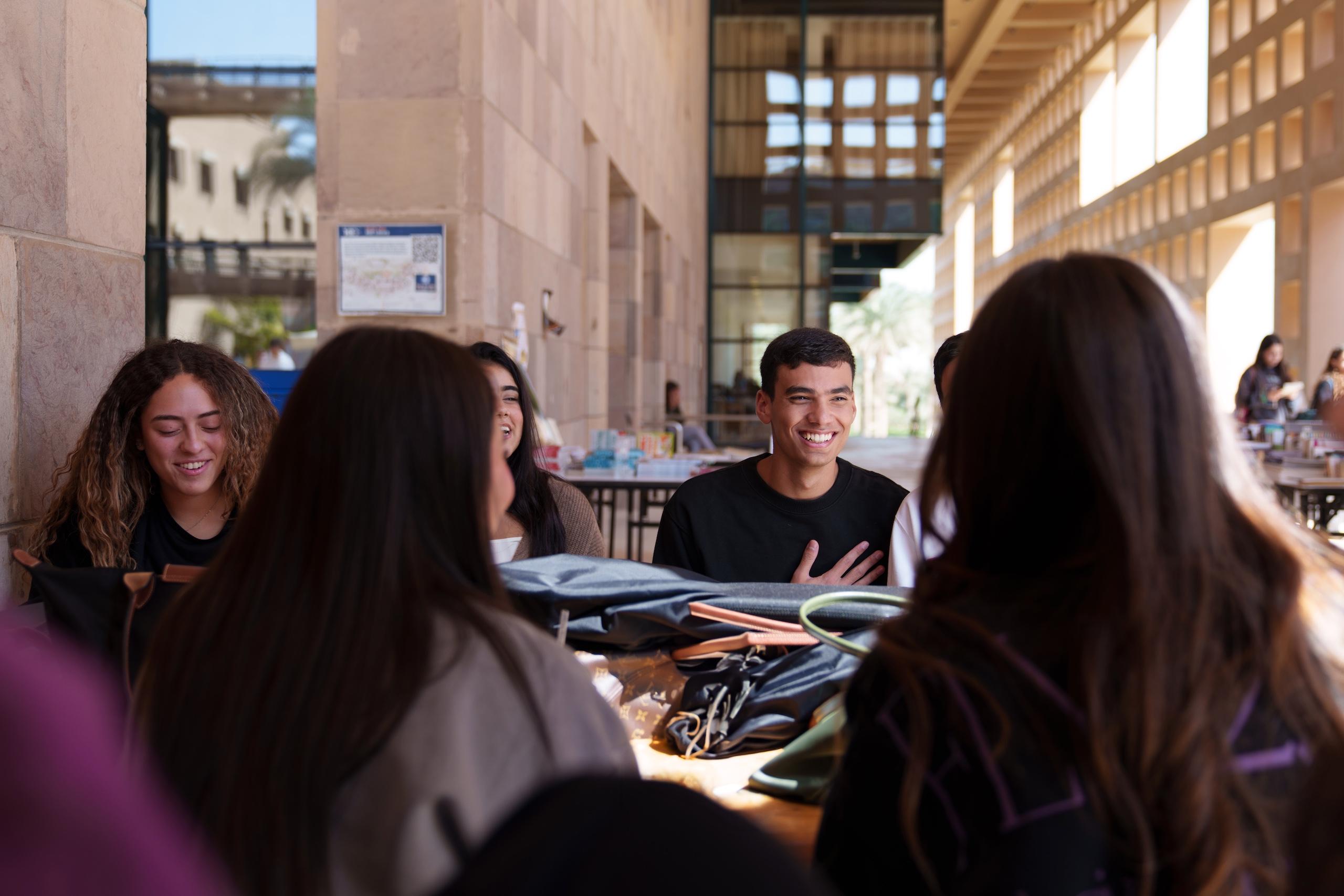 a group of girls and boys sitting together in the plaza area