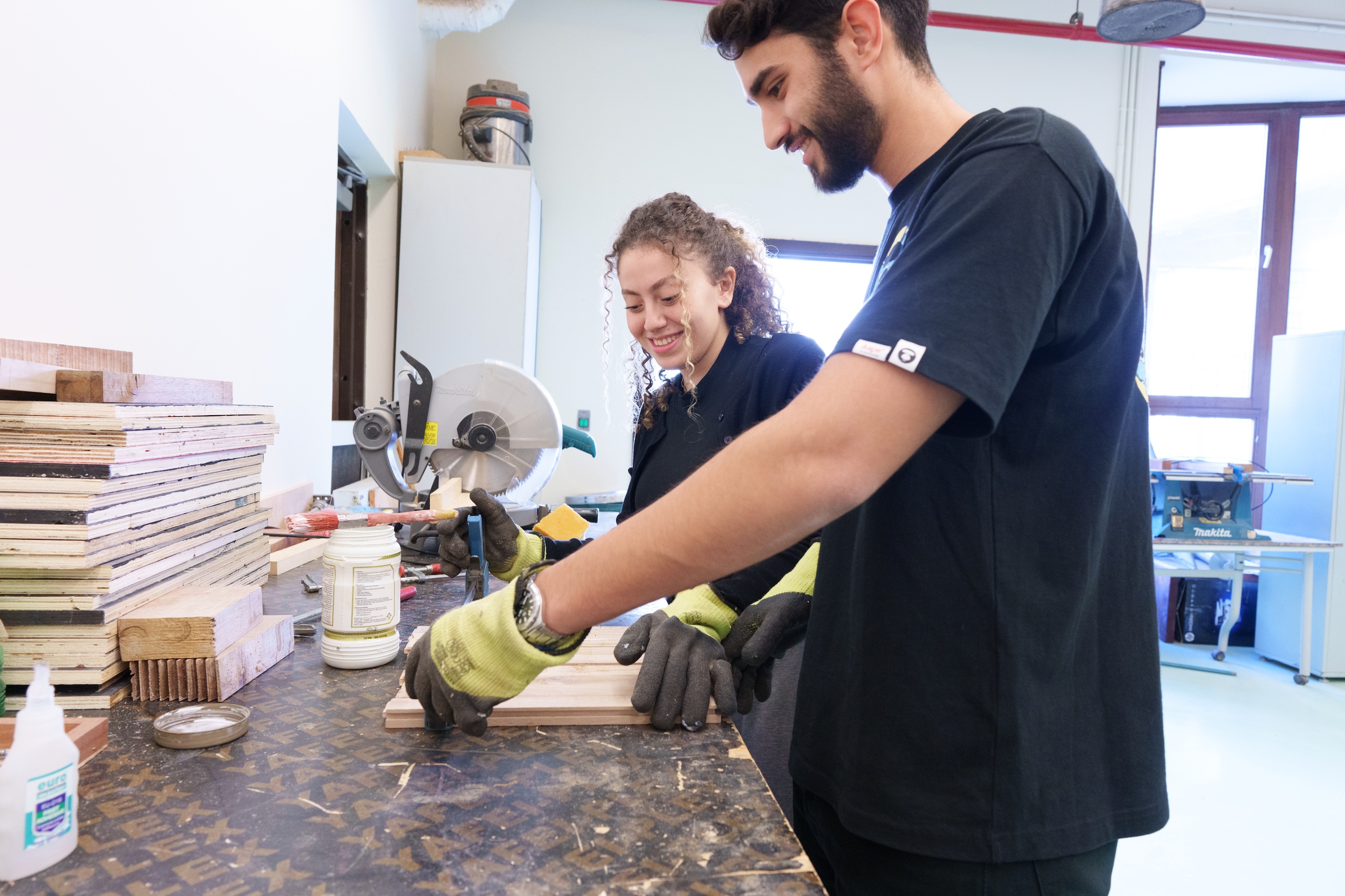 a girl and a boy wearing black tshirts working on an experiment in a lab