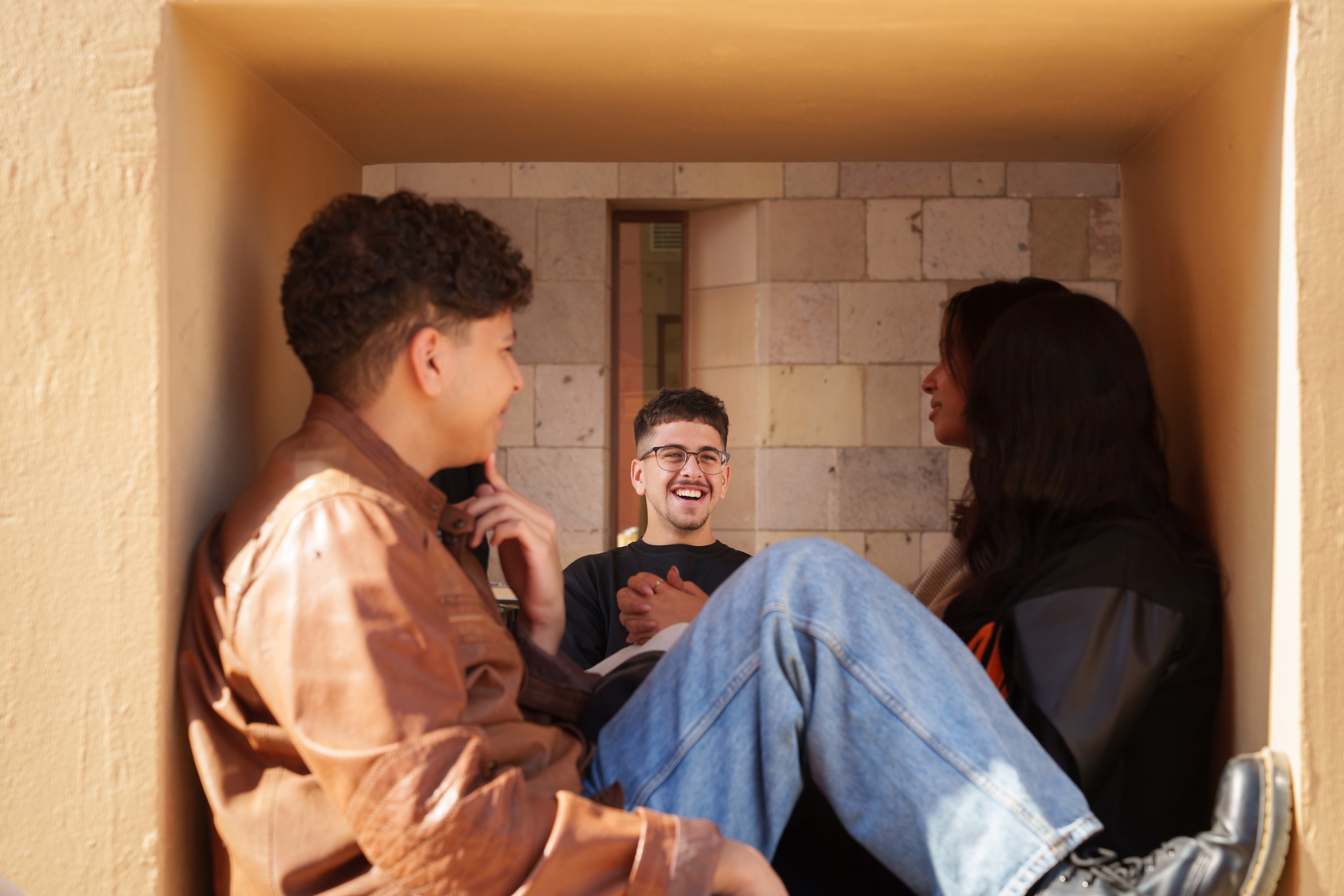 a girl and a boy sitting in the cubes with one student smiling at them