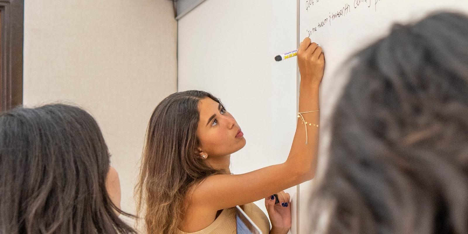 auc students in class writing on the board