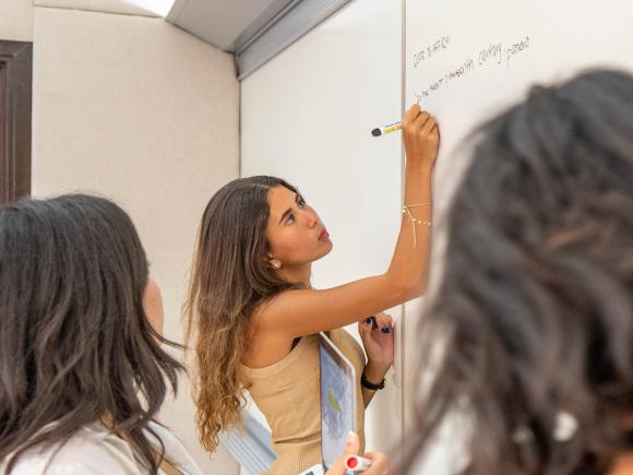 auc students in class writing on the board