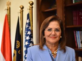 a woman with short brown hair wearing eye glasses and a light blue blazer