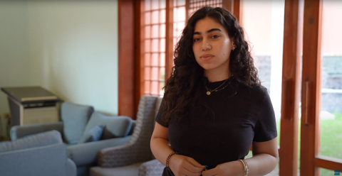 A Female student is standing inside a room